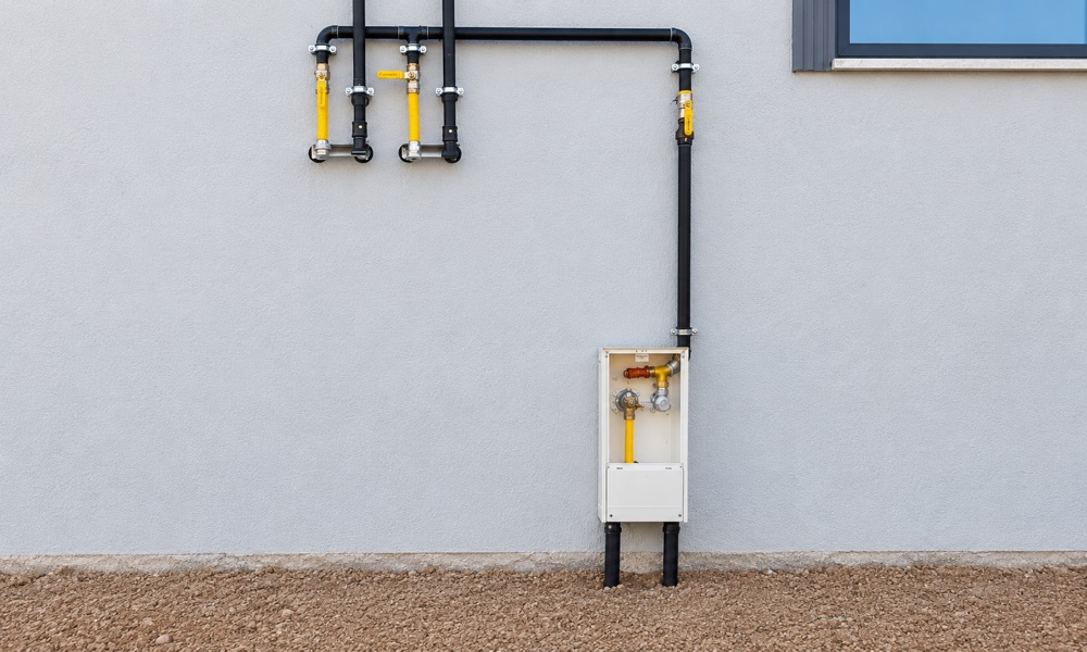 Duvara monte doğalgaz boruları, sarı vanalar ve gaz kutusu